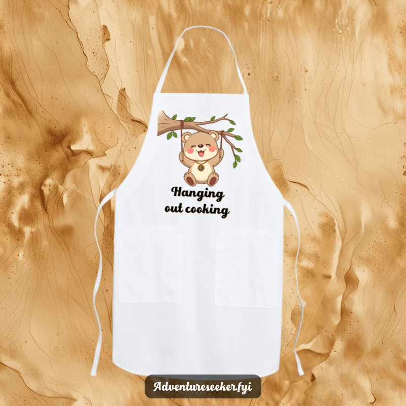 Funny Bear Cub Compass Apron. A bear cub with a compass necklace swinging from a branch adds adventure to kitchen duties.